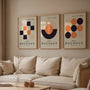 beige black and orange geometric bauhaus poster set in contemporary office workspace